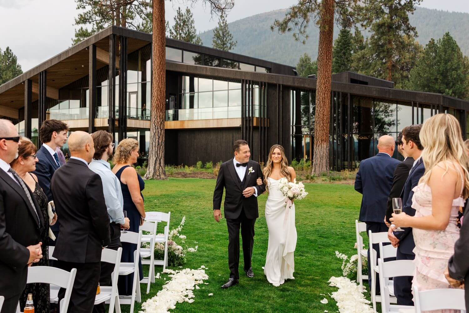 Father of the bride wearing tuxedo walking daughter down the aisle